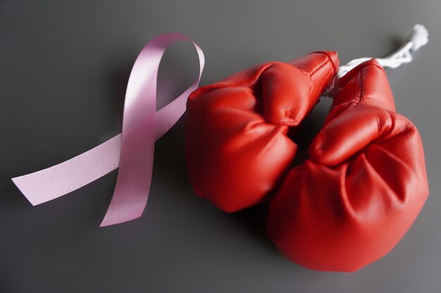 Image rapprochée de gants de boxe et de ruban rose Concept de sensibilisation aux survivants du cancer du sein