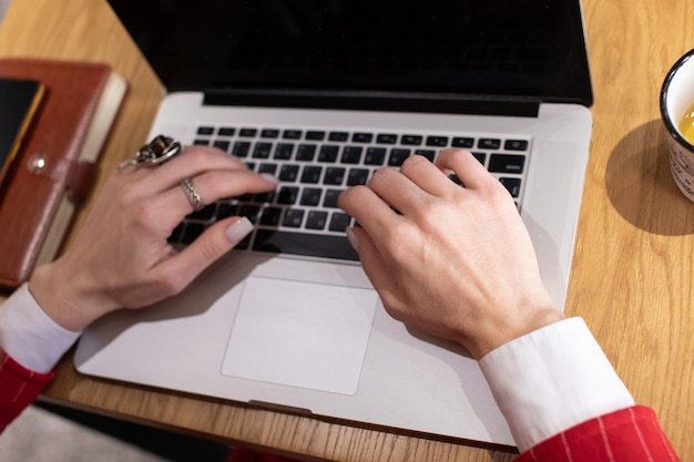 Image rapprochée de mains de femmes en train de taper sur le clavier d'un ordinateur portable