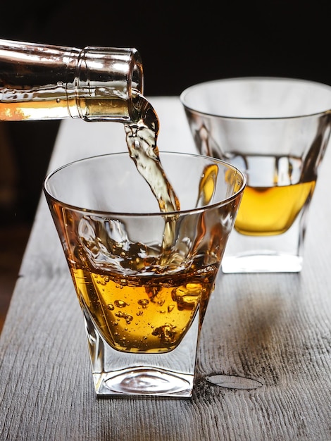 Image rapprochée d'un whisky versé d'une bouteille dans un verre