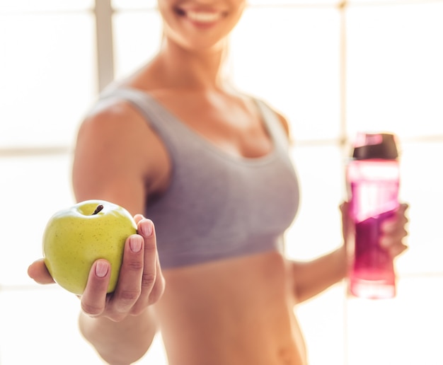 Image recadrée de la belle sportive jeune femme souriante.