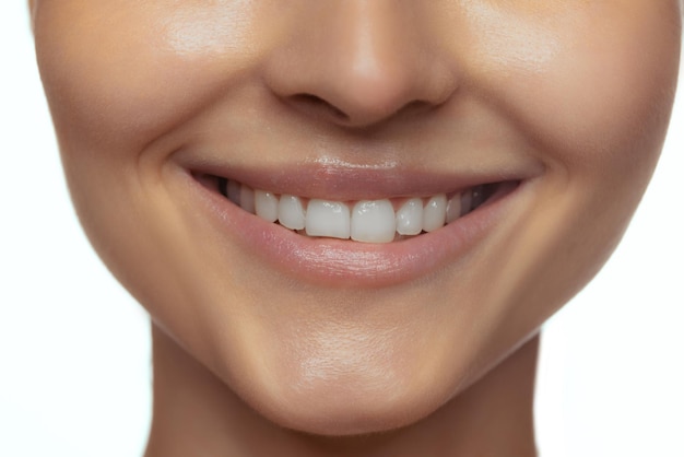 Image recadrée de belles lèvres féminines dents cou et menton isolés sur fond de studio blanc