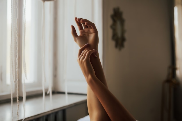 Image recadrée d'un couple tenant les mains dans la chambre.