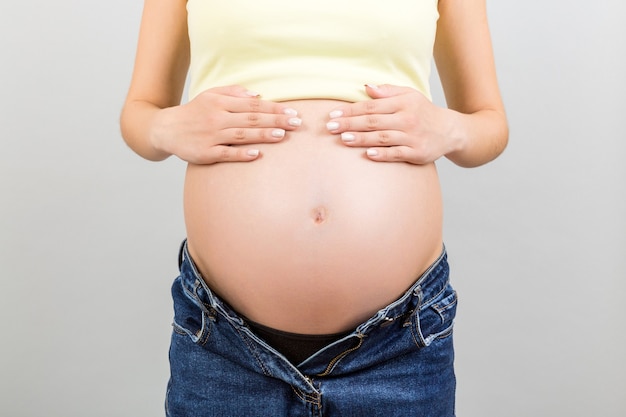 Image recadrée du ventre de femme enceinte à fond coloré avec espace de copie