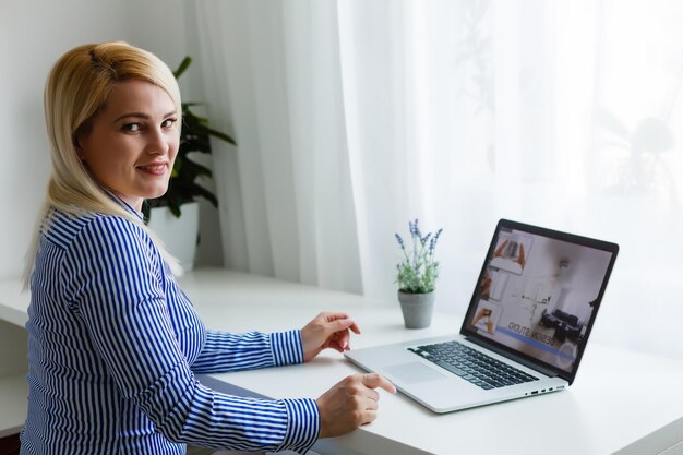 Image recadrée de femme d'affaires à l'aide d'un ordinateur portable au bureau