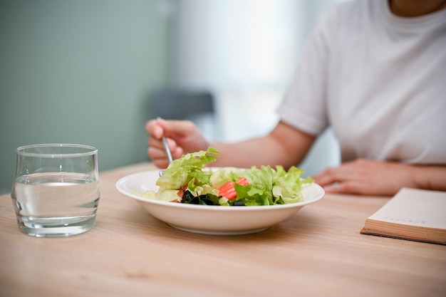 Image recadrée Une femme mangeant une salade saine à sa table à manger Mode de vie sain