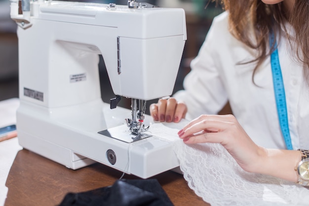 Image Recadrée De Femme Sur Mesure Couture Fine Dentelle Avec Machine à Coudre Assis En Studio De Couture