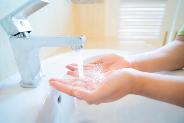 Image recadrée d'une femme se lavant les mains dans la salle de bain à la maison