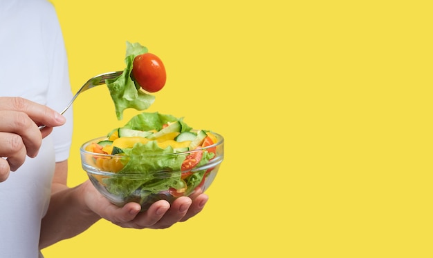 Image recadrée de femme tenant une assiette de salade de légumes