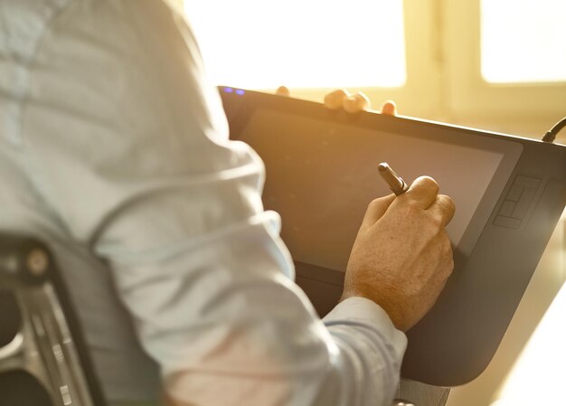 Photo image recadrée d'un graphiste travaillant avec un stylo à l'écran