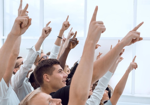 Image recadrée d'un groupe de jeunes pointant vers le haut