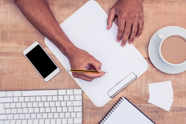 Image recadrée de l&#39;homme d&#39;affaires écrit sur un ordinateur portable par le clavier de l&#39;ordinateur au bureau