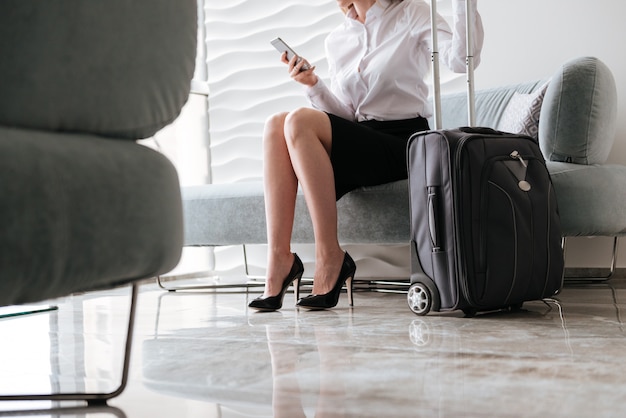 Image recadrée de jolie femme d'affaires à l'aide de téléphone.