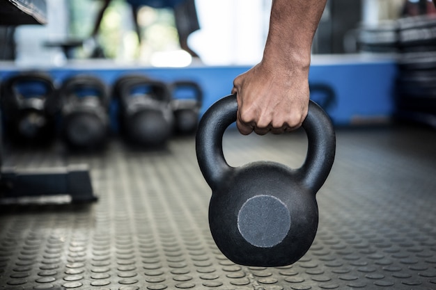 Image recadrée d'une personne tenant un kettlebell