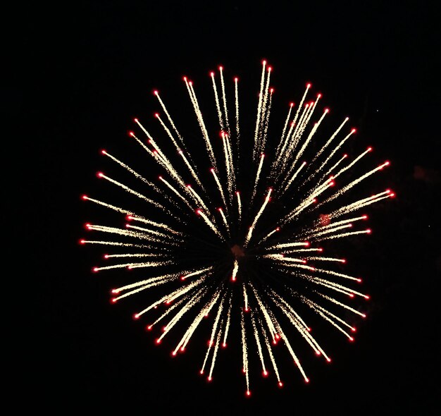 Photo image symétrique de feux d'artifice explosant dans le ciel noir