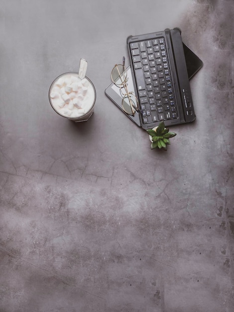 Image ton vintage de café avec des lunettes de cactus et un ordinateur portable sur une table en béton gris