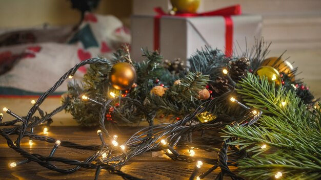 Image tonique de plan rapproché de lumière rougeoyante de Noël sur le plancher en bois au salon