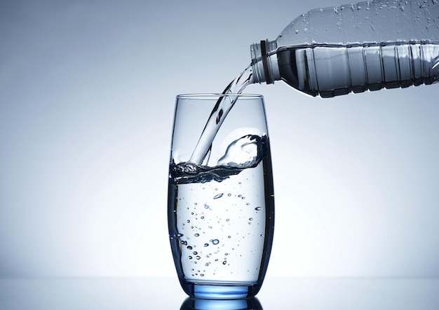 Image de verser de l'eau d'une bouteille d'eau dans un verre
