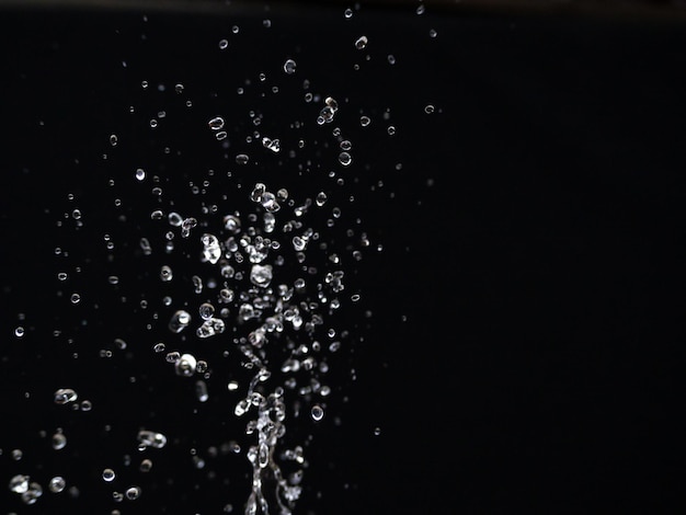 image verticale. L'eau éclabousse dans l'air. Vagues d'eau et gouttes d'air, mouvement naturel de l'air et de l'eau