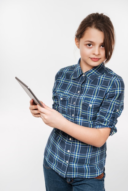 Image verticale de la jeune fille en chemise avec ordinateur tablette