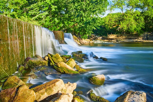 Photo image d'une vue latérale d'un barrage artificiel créant des chutes d'eau dans des roches d'algues