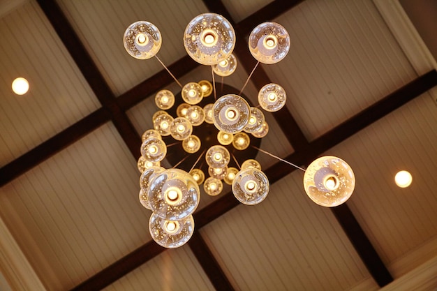 Image de Worm's eye view d'un lustre en verre composé de globes de verre sur un plafond à carreaux noir et blanc