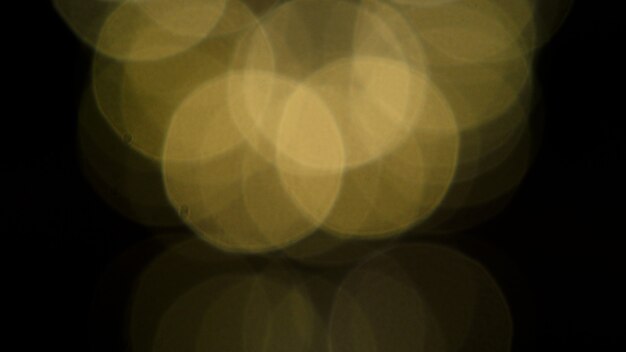 Les images de bokeh entourent les bulles de couleur jaune sur fond noir.