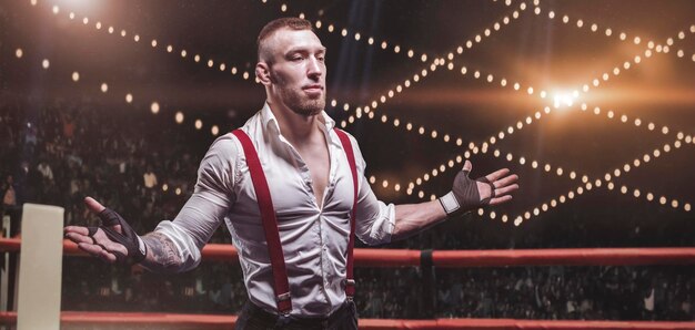 Images d'un homme barbu en chemise blanche et bretelles rouges dans le ring. Le concept de combats souterrains de poing. Technique mixte