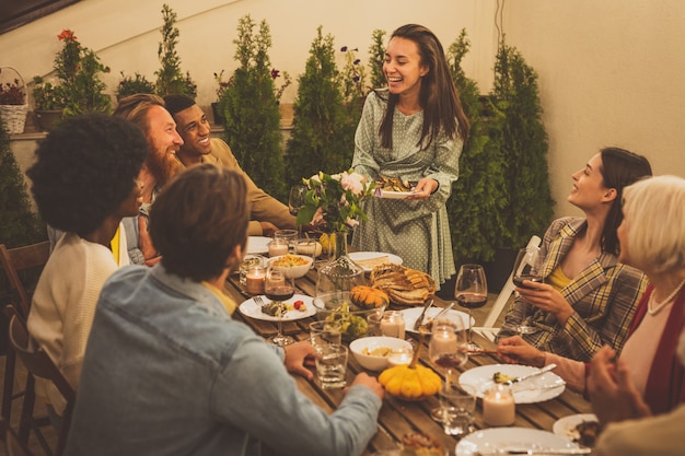 Images narratives d'un groupe multiethnique de personnes dînant sur un toit. Famille et amis se réunissent à la maison