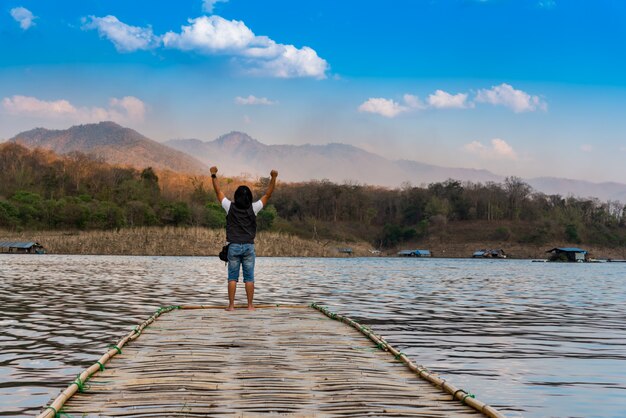 Images de paysages, le dos de touristes hommes debout sur un pont de bambou.