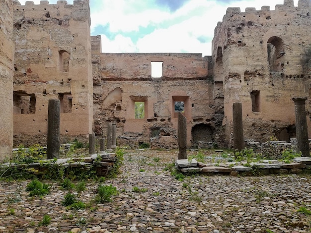 Images des ruines d'un vieux château vu de l'intérieur où l'on trouve des piliers, des éboulis, des tours du château et des vestiges antiques
