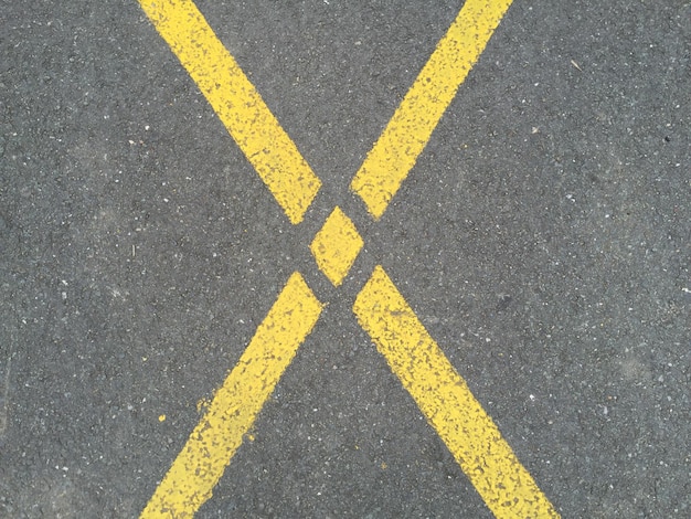 Photo immédiatement au-dessus de la marque jaune en forme de croix sur la route