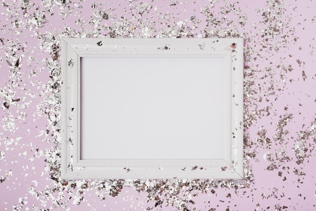 Photo immédiatement au-dessus de la photo d'un cadre blanc avec des confettis sur fond rose