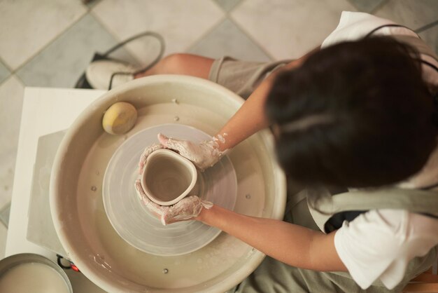 Photo immédiatement au-dessus de la photo d'une femme travaillant dans l'argile