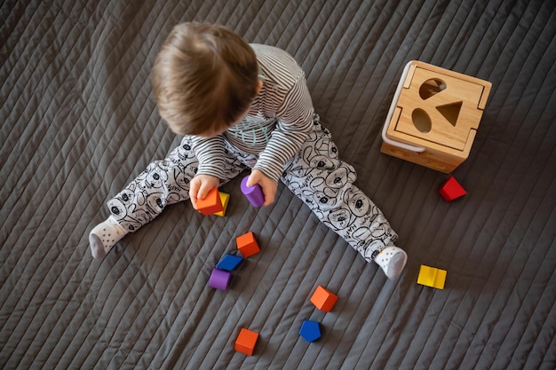 Immédiatement au-dessus de la photo d'un garçon avec le syndrome de Down jouant sur un tapis