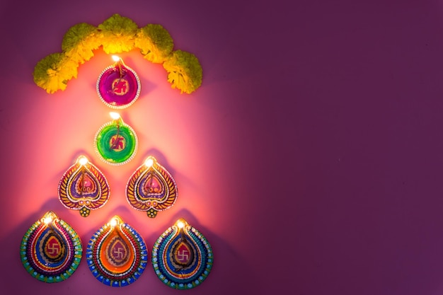 Immédiatement au-dessus de la prise de vue de diyas éclairés contre un fond rose