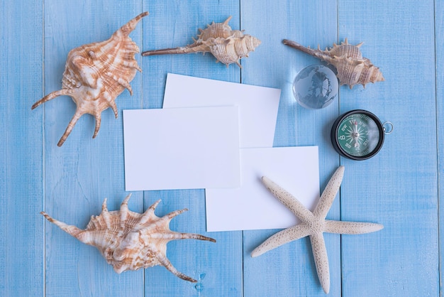 Immédiatement au-dessus, prise de vue de papiers blancs avec des coquillages et une boussole de navigation par boule de cristal sur table