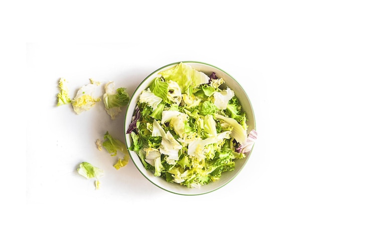 Photo immédiatement au-dessus de la salade de fruits dans le bol sur fond blanc