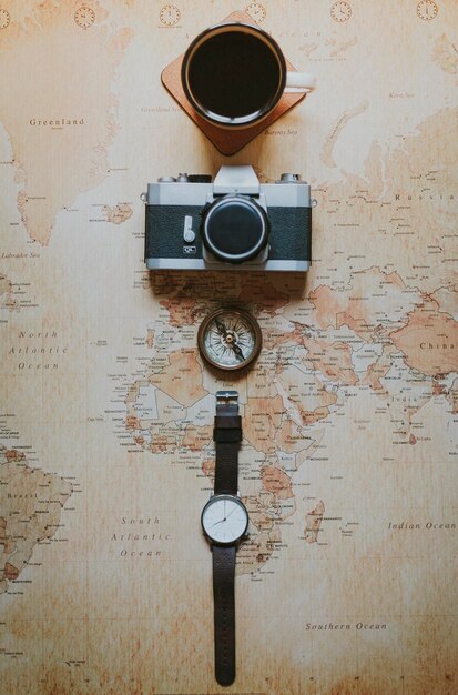 Immédiatement au-dessus de la tasse de café avec caméra et boussole de navigation sur la carte du monde