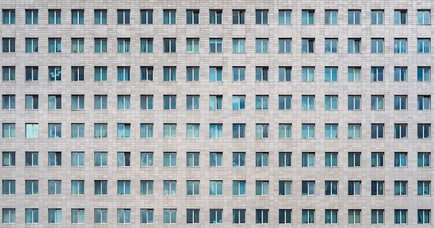 Immeuble de bureaux moderne. Windows d'un gratte-ciel à plusieurs étages. Des rangées de fenêtres identiques.