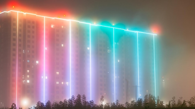 Immeuble avec éclairage par temps de brouillard Néons dans le brouillard