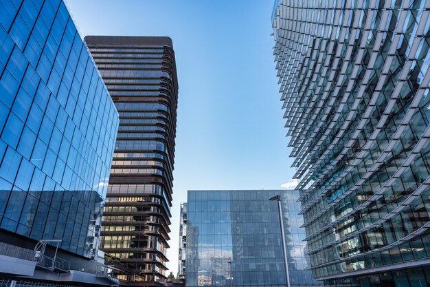 Photo des immeubles de bureaux modernes qui reflètent dans leurs fenêtres d'autres gratte-ciel de madrid