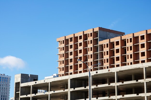 Immeubles de grande hauteur inachevés contre le ciel bleu