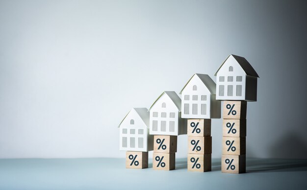 Photo immobilier ou concepts de risque immobilier avec signe de pourcentage et modèle de maison sur l'étape de bois. investissement commercial et financier.