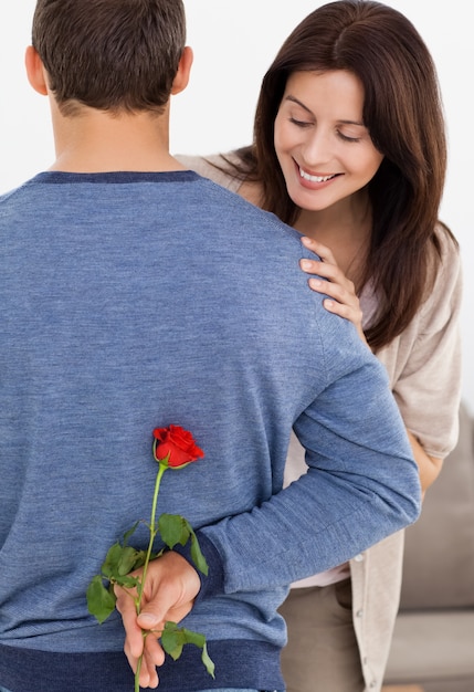 Impatiente femme regardant une fleur cachée par son petit ami