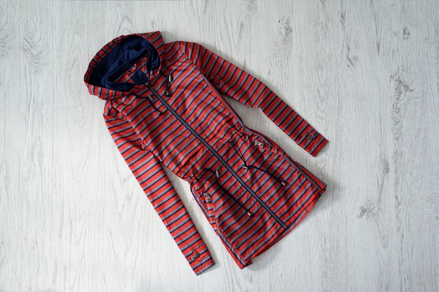 Imperméable à rayures rouges et bleues sur bois.