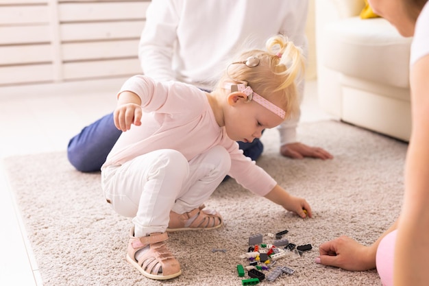 Implant cochléaire pour bébé enfant sourd avec appareil auditif joue dans le salon