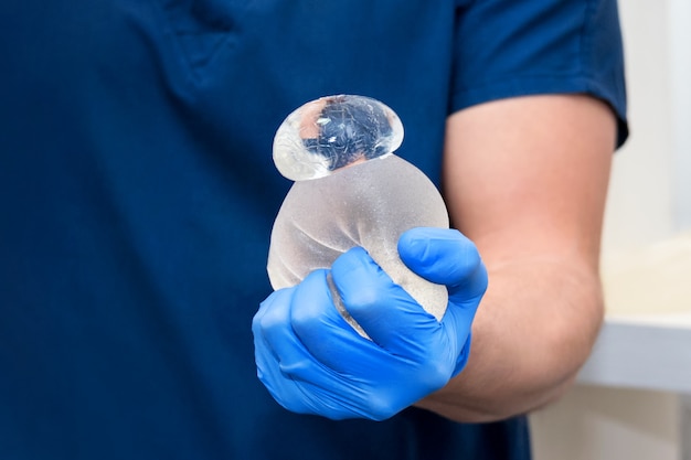 Implant mammaire d'ours gommeux déchiré endommagé dans les mains du chirurgien