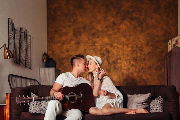 Impressionnant jeune homme et femme en vêtements blancs avec guitare