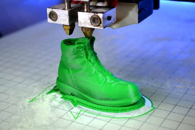 Une imprimante 3D imprime la forme de plastique fondu vert