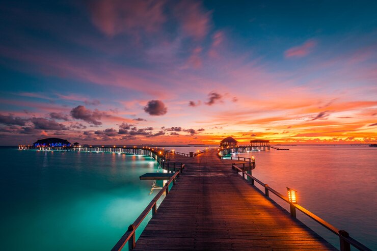 Photo incroyable coucher de soleil aux maldives. paysage marin de villas de luxe, fantastiques nuages de ciel colorés, vacances